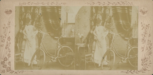 Stereo photograph of woman pumping up bicycle, circa 1870